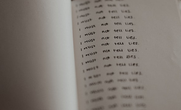 Photo of a page with handwriting repeating &#039;I must not tell lies'