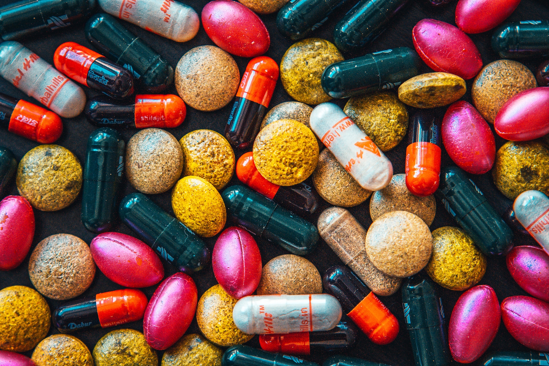 A photo of numerous pills and capsules in many different colours