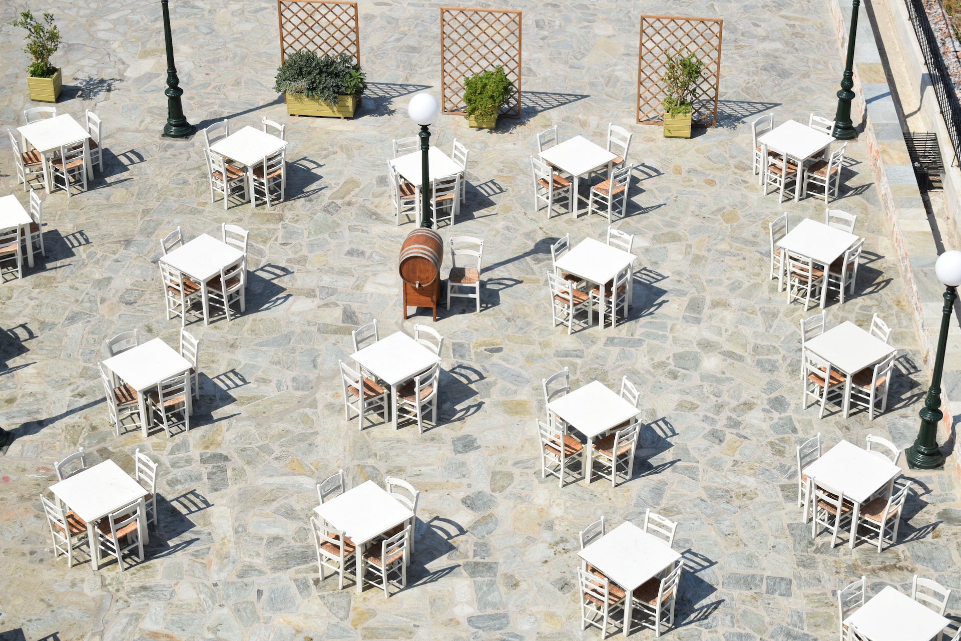 Photo of many small white tables in an outdoor courtyard