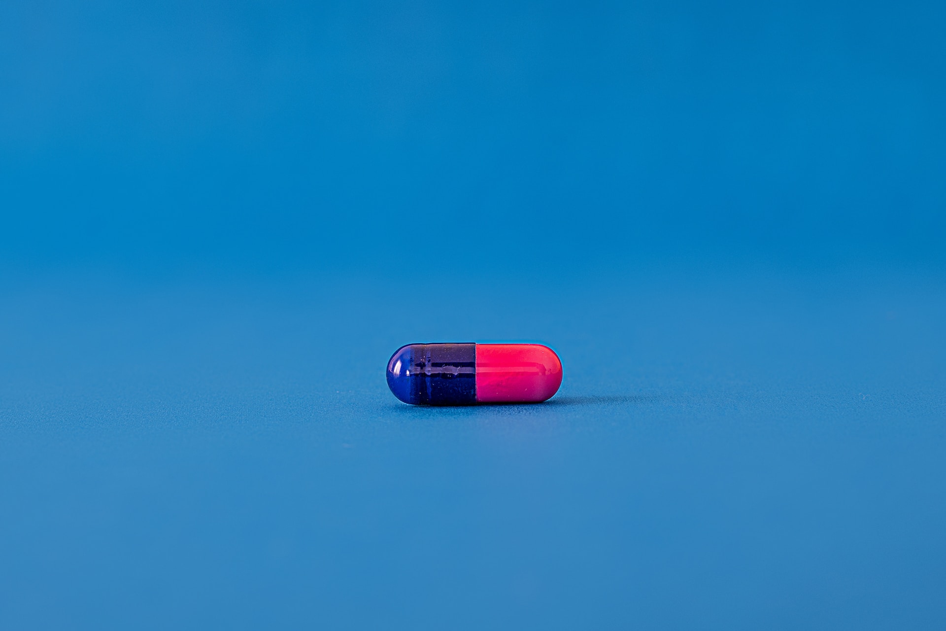 Pink and blue pill against a blue background